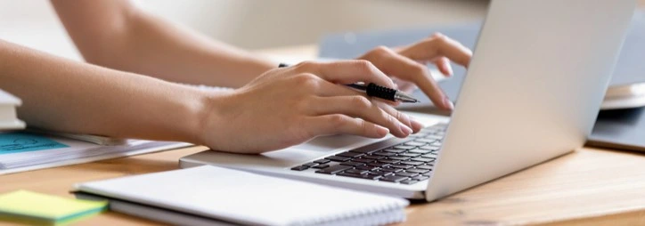 A student typing on the computer