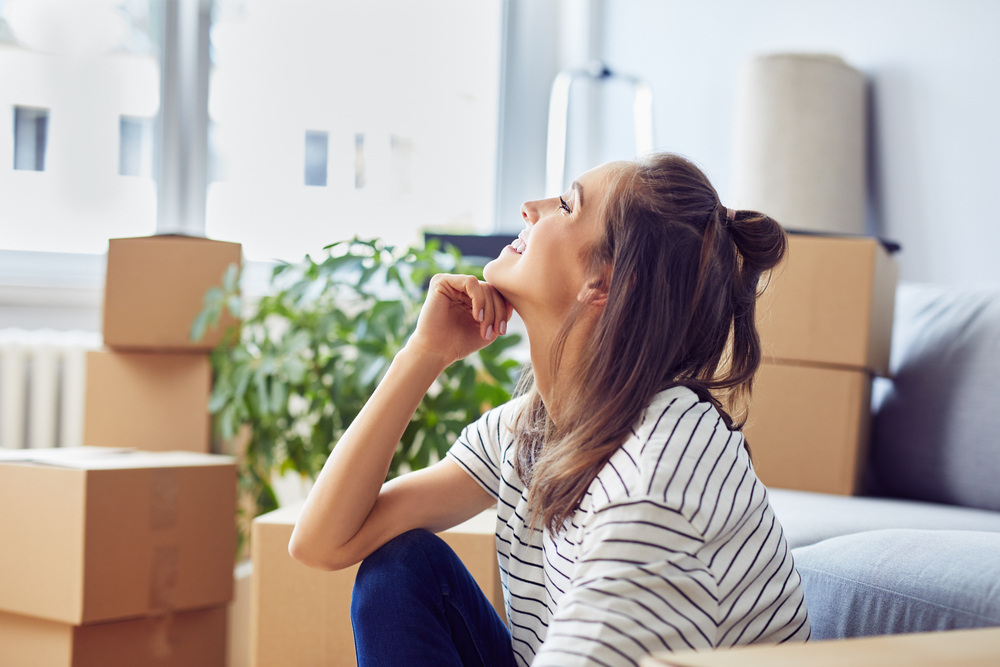 Young woman surrounded by moving boxes.