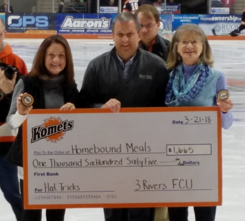 3Rivers donating a check to Homebound Meals during a Komets hockey game.