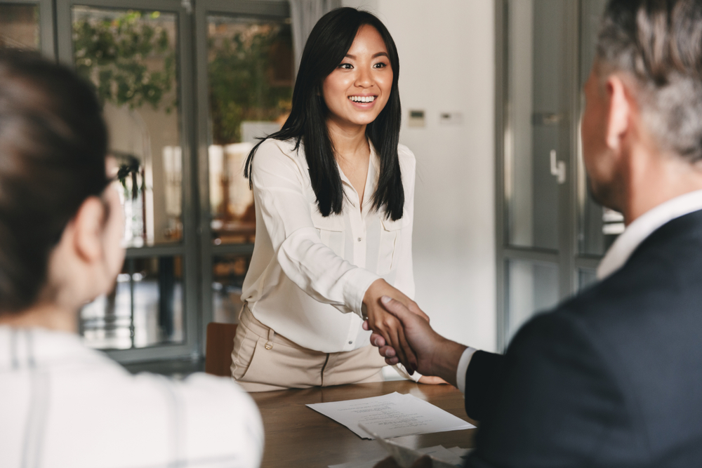 Young woman shaking hands with job interviewer.