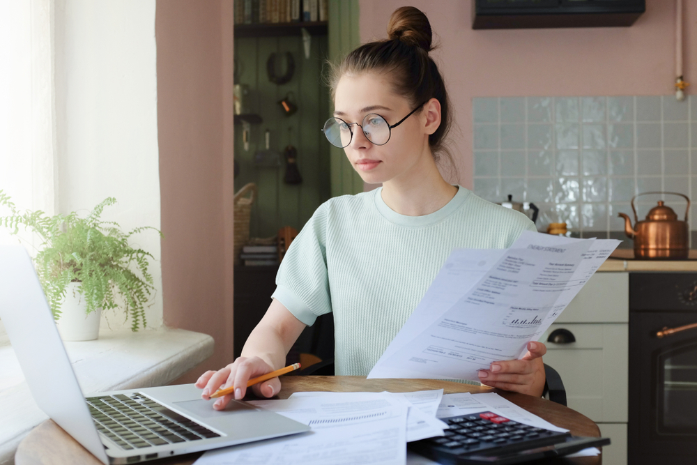 Young Woman Sitting at Table Working on a Budget