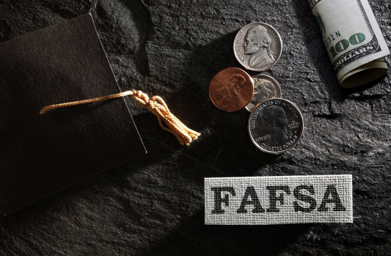 Graduation cap and money on a black background.