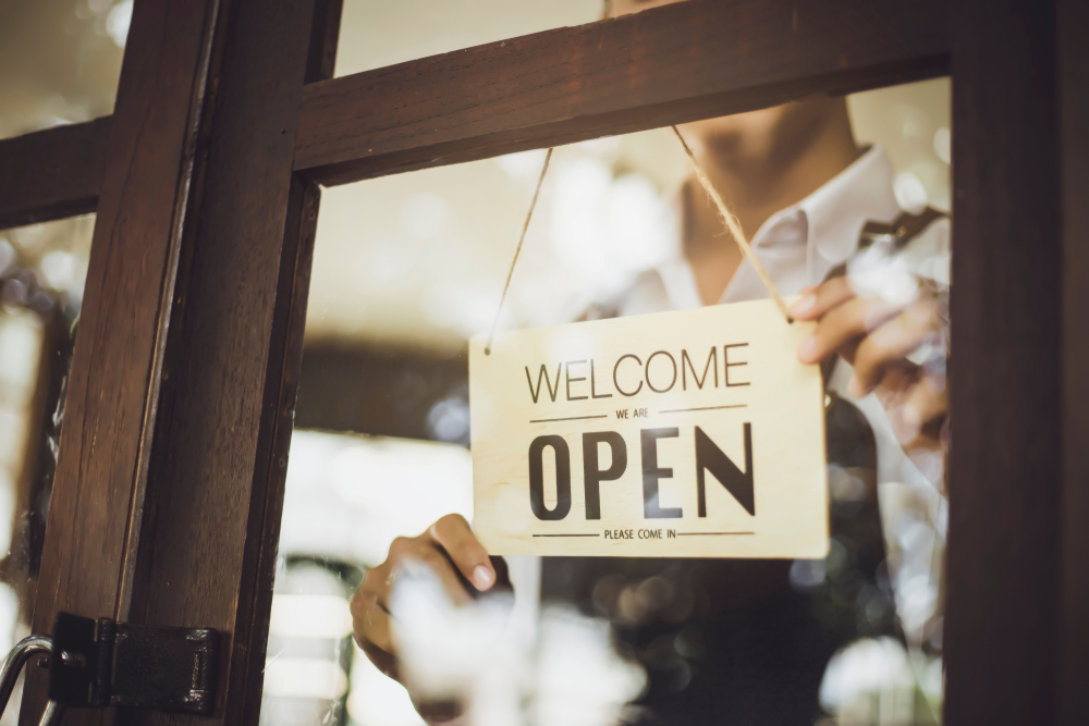 Small Business Owner Putting Up Open Sign