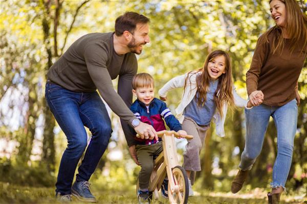 Young Family Walking Through Woods