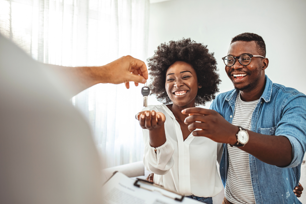 A young couple getting the keys to their new home.