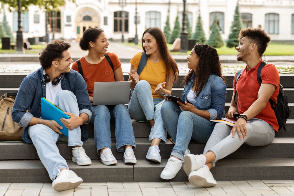 College students sitting outside on stairs.