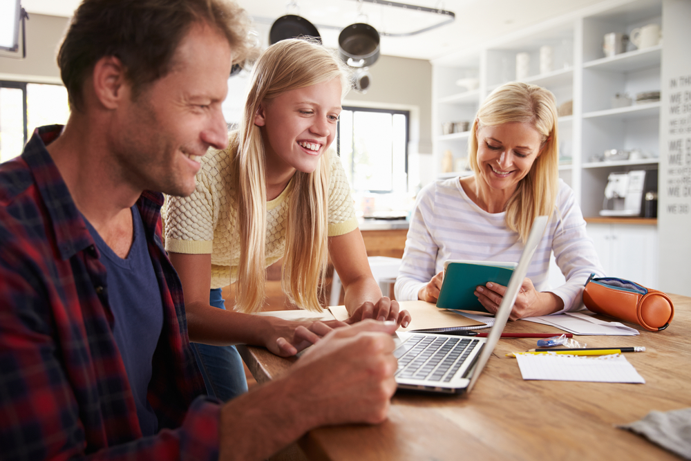 Teenager on laptop with her parents.