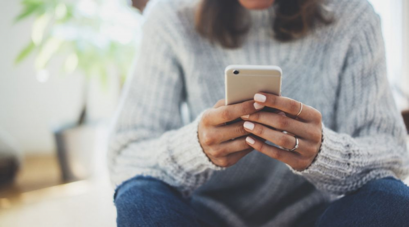 A close-up of hands using a mobile phone.