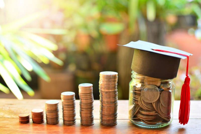 A series of stacked coins ending with coins in jar and a graduation cap.