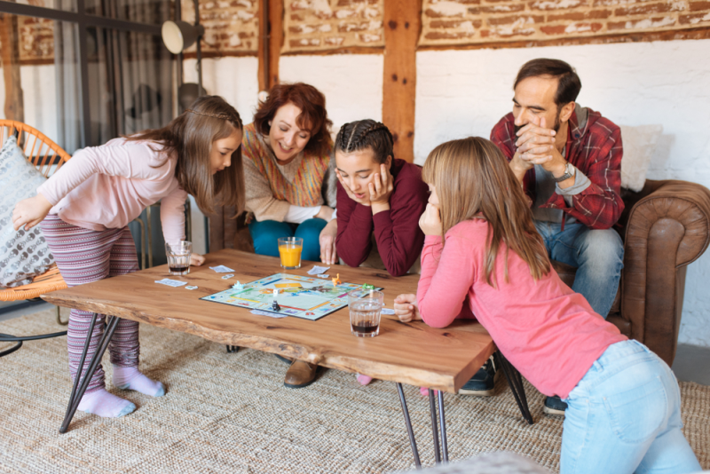 Family playing board games in living room.