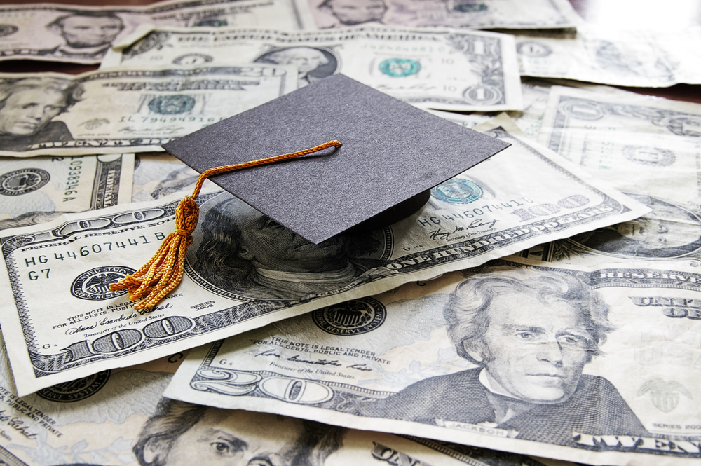 Graduation cap sitting on top of cash.