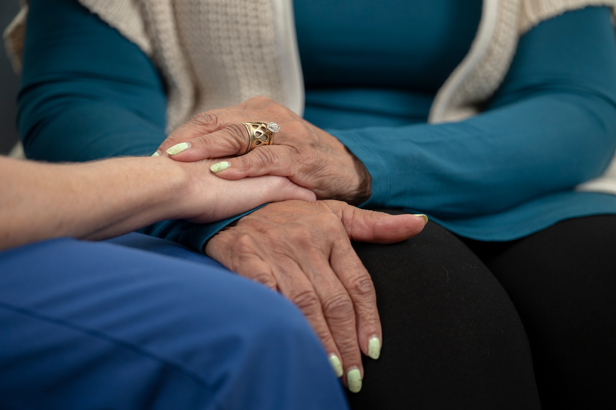 A Stillwater Hospice caregiver's and patient's hands.