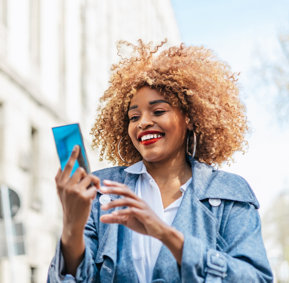 A woman smiling and looking at her phone