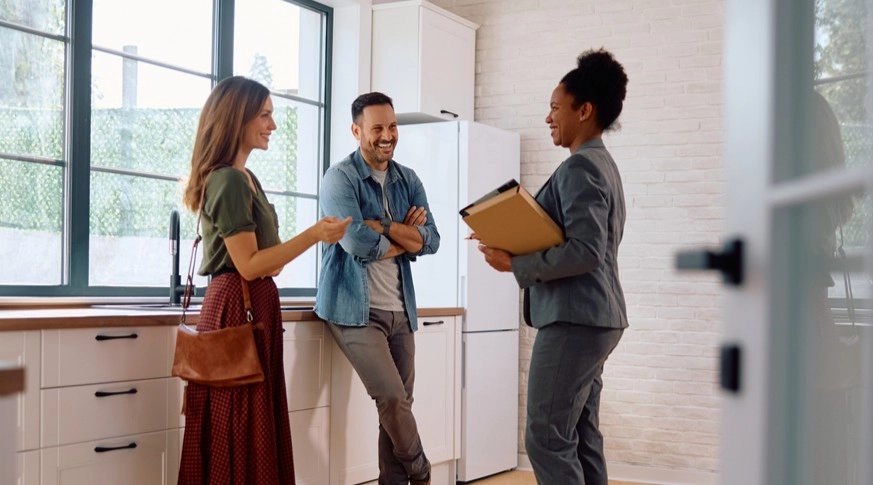 A young couple viewing a new home with a real estate agent