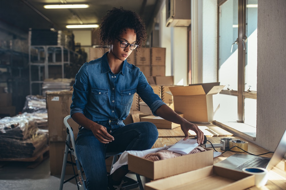 Small business owner putting together an order to mail.